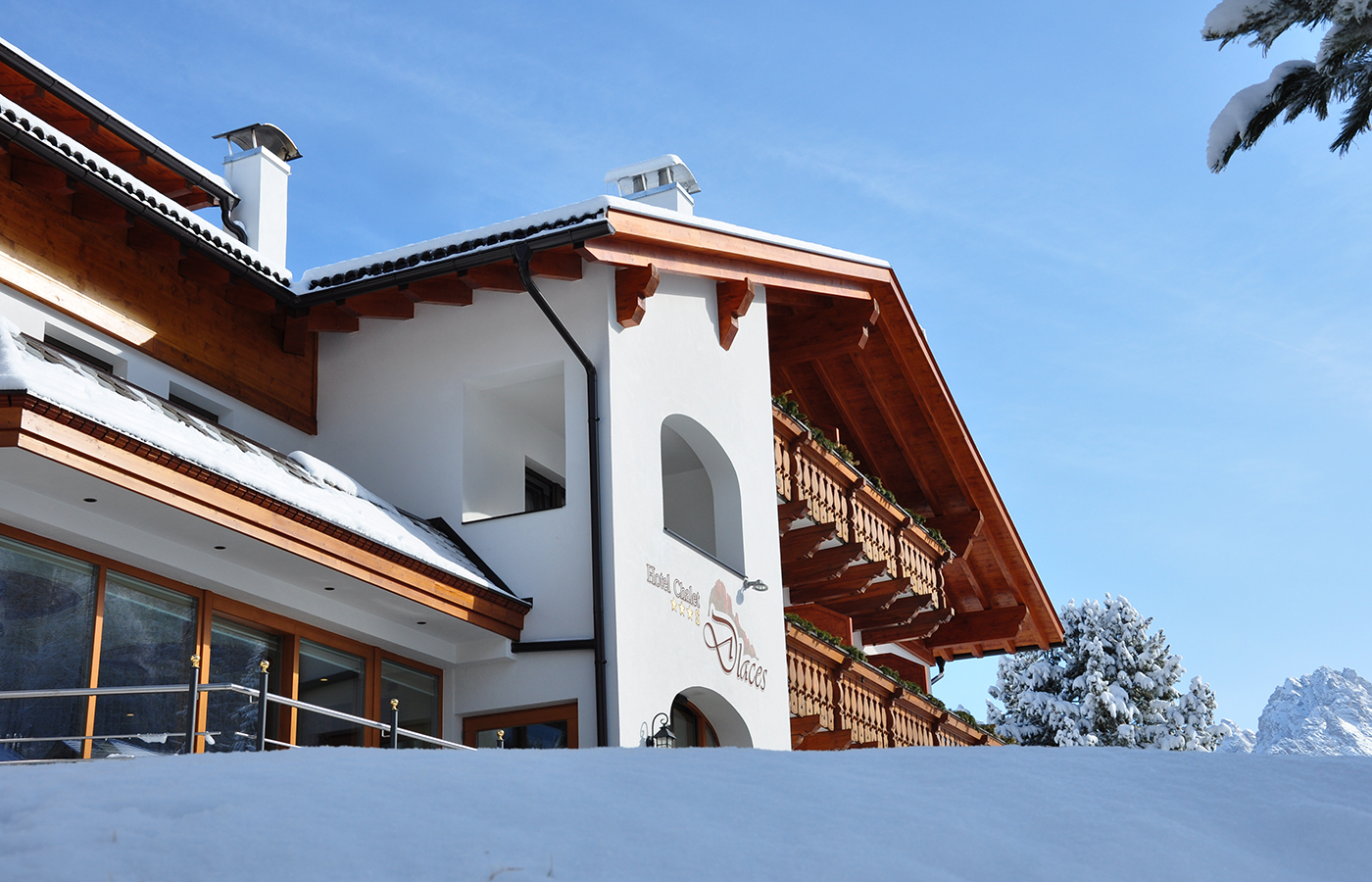Facciata dell’Hotel Dlaces in stile alpino con neve