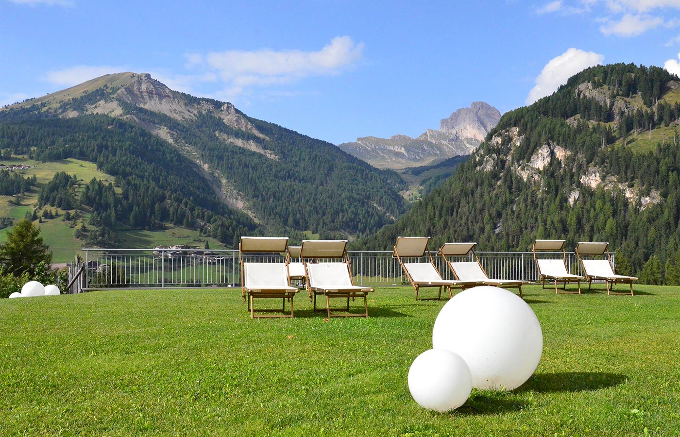 der Garten des Chalet Dlaces mit Sonnenliegen im Sommer