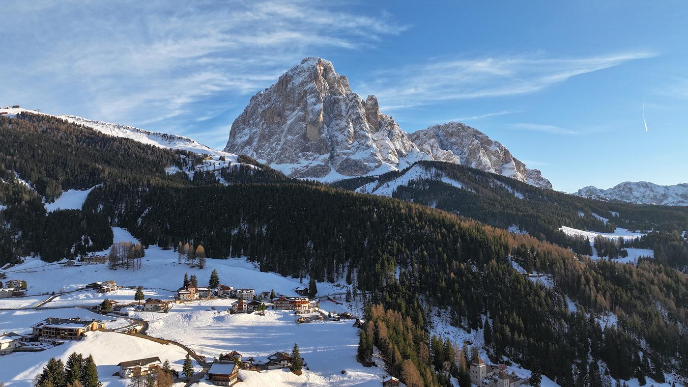 Das schneebedeckte Dorf Wolkenstein vom Chalet Dlaces aus gesehen